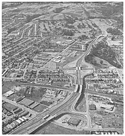 View directed west as-completed c. 1963, showing full cloverleaf interchange with SR 82, center, and bridges over SP's Peninsula Corridor