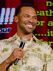 Epps holding a microphone, smiling