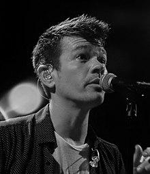Ruess singing into a microphone