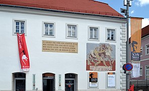 Photo couleur d'une façade de maison blanche avec affiches colorées