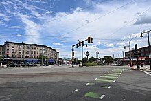 This image is an August 2024 view of the Boston Neighborhood, Cleveland Circle from the intersection of Beacon Street and Chestnut Hill Avenue. The image is looking east down Beacon Street. Prominent landmarks shown in the photograph are the Cleveland Circle neighborhood, the Cityside restaurant, and the Cleveland Circle Station, which serves as terminus of the MBTA C line. It also shows the primary commercial drag of the neighborhood, which goes though this portion of Cleveland Circle.