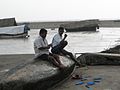 A fisherman repairing his net