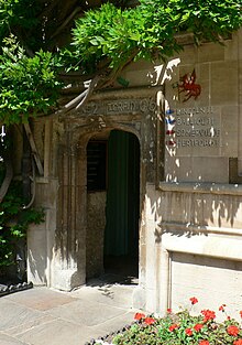 An open square-topped stone archway, with a flower bed to the right and leaves growing above; written on the top of the arch "Men's 2nd Torpid 06"; to the right, a red dragon holds a green flag, above the words "Lincoln II / Balliol II / Somerville / Hertford II"