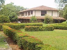 Modern two-story building, with a lawn and hedges on the side