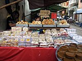 A streetside vendor in Latha Township (also known as "China Town") selling Chinese baked goods, including tikay and paste-filled buns.