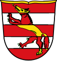 Gemeinde Fuchsstadt In Rot zwei silberne Balken, aufgelegt ein von Gold und Rot wechselnd geteilter Fuchs.