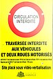 Panneau informant de l'interdiction de circuler à certains véhicules sur la place Jean-Jaurès. Il indique : « Circulation interdite. Traversée interdite aux véhicules et deux-roues motorisés. Art. R 412-7 2 du Code de la route / R110-02 du Code de la route / R311-1 du Code de la route réprimé par Art. R412-7 3 du Code de la route - 135 euros Site placé sous vidéo verbalisation ». En bas au centre se trouve le logo de la ville de Marseille ainsi que ses armoiries.