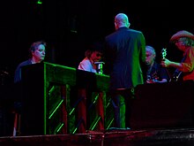 Musicians huddled around a piano