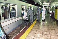 GSDF personnel (with olive-drab colored clothing) and TMPD officers (with white clothing) entering contaminated vehicles.