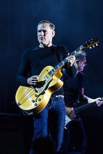 Man in a black shirt playing a guitar