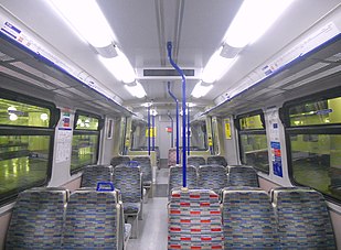 Image showing the interior of a Class 315, with 2x3 seating, grey and blue (or red) moquettes and blue grab poles.