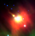 Proplyd imaged by the Spitzer Space Telescope is the elongated object on the upper left. 42 Orionis is in the middle and it is surrounded by glowing dust.