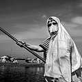 Algerian woman fishing with her haik.
