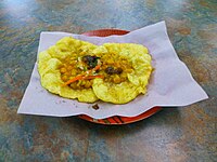 Doubles is a common Trinidadian and Tobagian street food made with two baras filled with curried chickpeas and various chutneys.