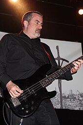 B. C. Green playing bass to a backdrop of apocalyptic imagery