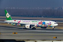 Side view of aircraft in flight; fuselage painted with Sanrio Characters' faces.