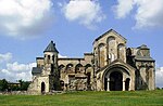 Ruins of a stone church with the highest point located at the apsis.