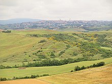 Le Crete; campagna senese con la città sullo sfondo lungo la via Lauretana.