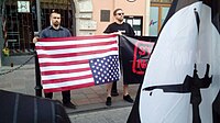 Two young men holding An American flag upside down