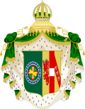 Coat of arms consisting of a shield with a green field with a golden armillary sphere over the red and white Cross of the Order of Christ, surrounded by a blue band with 20 silver stars; the bearers are two arms of a wreath, with a coffee branch on the left and a flowering tobacco branch on the right; and above the shield is an arched golden and jeweled crown