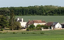 Photographie en couleurs d'une ferme aux nombreux bâtiments.