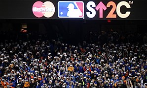 Fans pay tribute by standing with signs during game 3 of the 2015 World Series