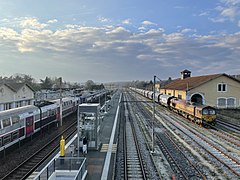 Les voies de services à droite et le bâtiment marchandises. Une Class 66 et sa rame y stationnent en attendant le départ.