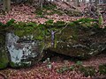 Un rocher transformé en oratoire dans la forêt.