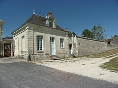 Photographie en couleurs d'un pavillon flanquant un portail