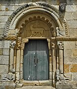 Puerta lateral de la iglesia de San Pedro de Rates con el Agnus Dei: el Cordero de Dios cargando una cruz.