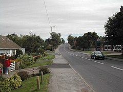 Road lined either side with housing and fuel station