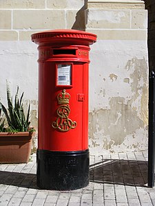 A red pillar box in Vittoriosa, Malta. In the 1980s, royal cyphers were ground off the pillar boxes in Valletta and Floriana, but most others remained intact.[21]