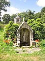 La fontaine dans l'enclos de la chapelle Saint-Exupère, laquelle est visible à l'arrière-plan.