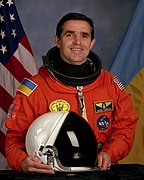 Leonid Kadenyuk at NASA, note different shades of blue on the patch and on the flag behind (1997)