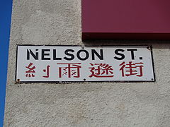 A sign reading Nelson Street, with text in Chinese underneath.