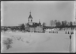 Petsamo klosterkyrka i Petjenga i vinterlandskap omkring 1911. Präster på väg hem. Foto: Ellisif Wessel