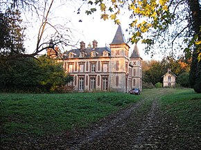 Photographie en couleurs d'un grand bâtiment dans un cadre de verdure.