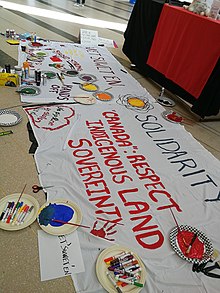 Image of banner created by participants of a Wetʼsuwetʼen Solidarity event at Vari Hall, March 11. The banner is painted with the phrases "Wetʼsuwetʼen Solidarity", "stand strong", "hands off", "no pipeline on stolen land", " "Canada": respect indigenous land sovereignty"