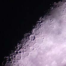 Lunar craters as captured through the backyard telescope of an amateur astronomer, partially illuminated by the sun on a waning crescent moon.