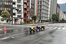 3 wheelchair marathon racers during race on road