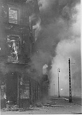 NARA copy #28 A housing block being destroyed Zamenhofa Street looking North, with burning Zamenhofa 25 / Wołyńska 2 on the left.