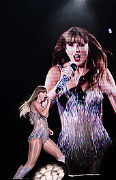 Swift singing onstage as a screen projects her