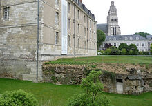 Vue d'une porte étroite percée dans une muraille arasée.