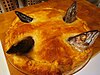 A baked stargazy pie, with fishheads showing