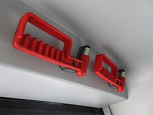 Photographie en couleurs de marteaux brise-vitres rouges dans un minibus gris