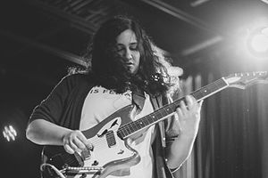 A young woman playing guitar