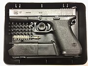 Le Glock 17 « première génération » de 1983, présentée avec ses accessoires dans sa boîte en plastique d'origine.