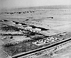 A black and white image of some hangars, tentage and hard standings in a desert