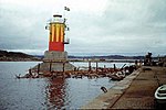 Oskarsgrundet nordost efter sjösättningen i Lysekil (med resterna efter den sprängda uppålningen flytande i vattnet). Det rödgula mönstret ersattes med svart-vitt när fyren bogserats på plats och förankrats.