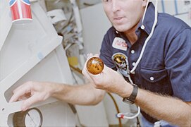 Story Musgrave avec une goutte de Pepsi flottant devant lui